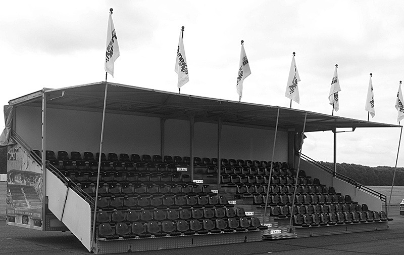 KL Seating GS150 covered spectator seating — 150 seats, built and flagged with black seats at a race day